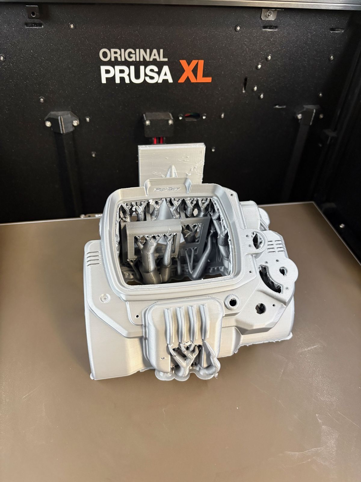 Díl z bílého PETG s podporami ze šedého PLA na tiskárně Prusa XL